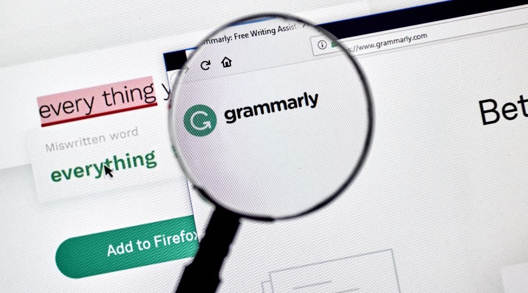 A close-up of a web browser displaying a magnifying glass hovering over and enlarging the green Grammarly logo.