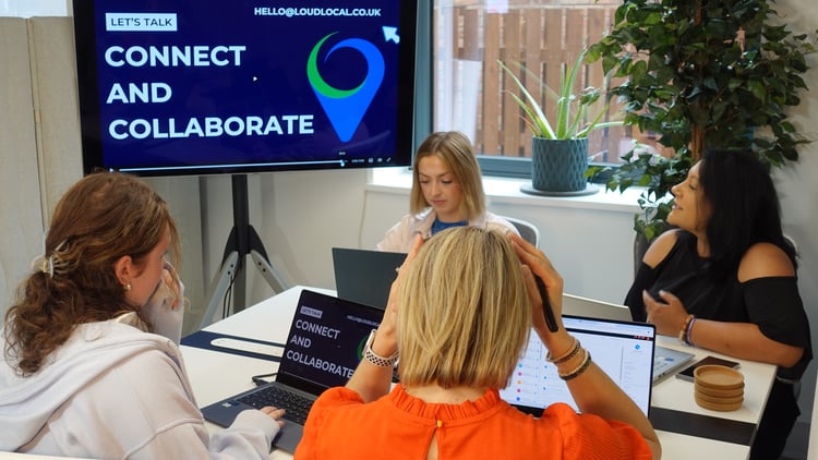 The LoudLocal team having a meeting together discussing 'connecting and collaborating'.