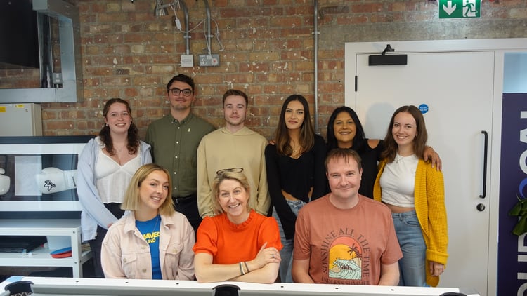 A photo, taken in the office, of the LoudLocal team members all stood together posing.