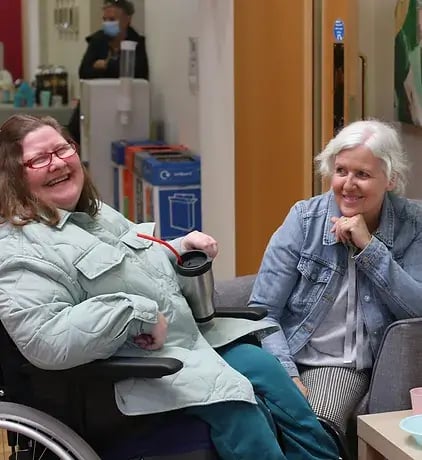 The Action Group is one of LoudLocal's clients. This image shows two women sat smiling in one of the Action Group's support centres.