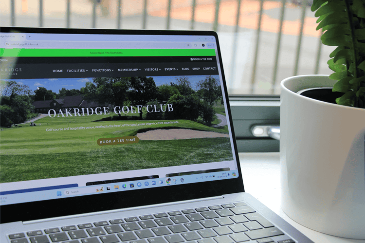 A photo taken of a laptop with Oakridge Golf Club's homepage to showcase website design.