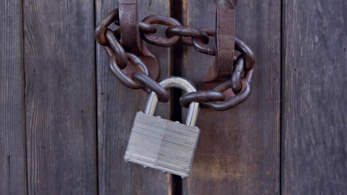 Image of a padlock and chain on a wooden door, indicating when someone gets locked out of their own business advertising accounts