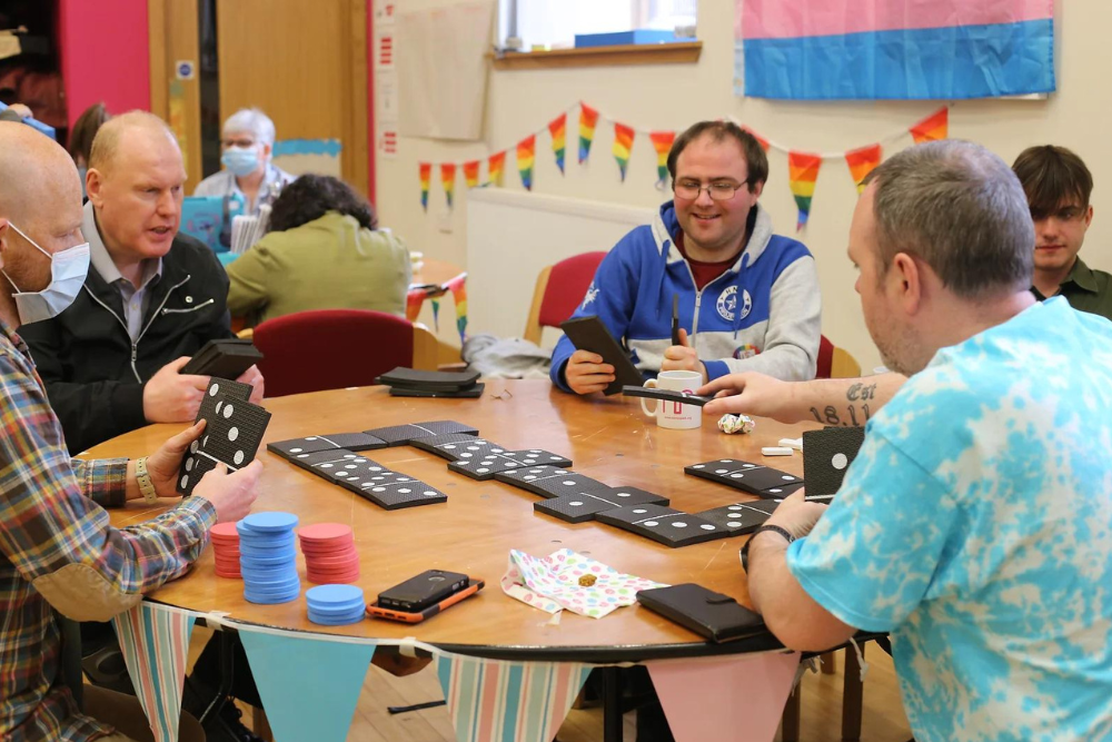 People sitting round a table at the action group playing games