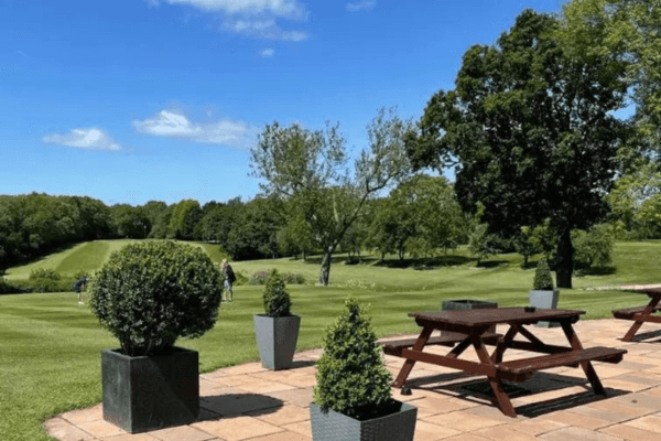 Oakridge golf club is a client of LoudLocal. This image shows the outside of the club house with picnic benches overlooking the greens.