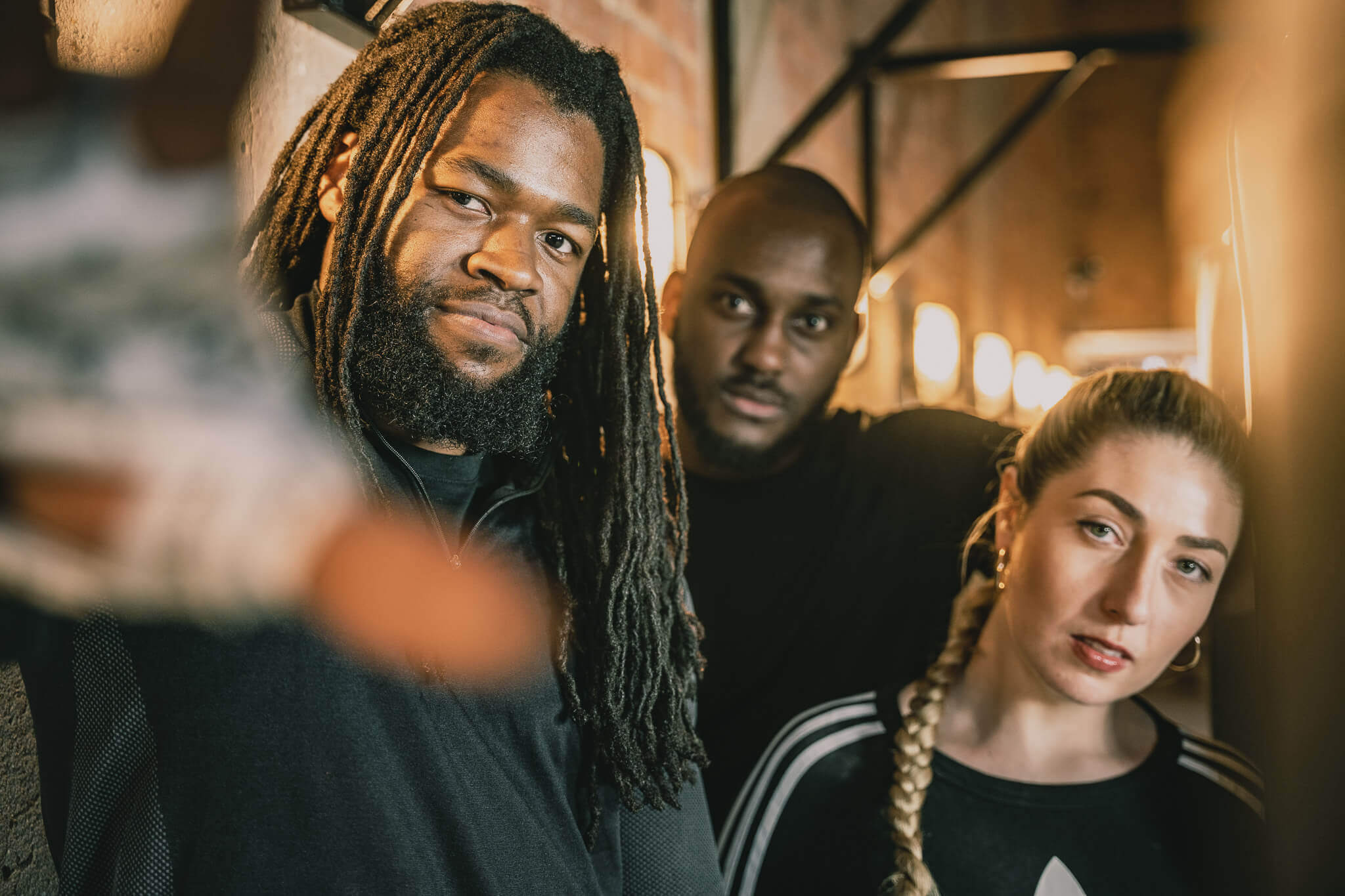 Bronx Boxing is a client of LoudLocal, this image shows 3 people including Marnie the founder of Bronx stood at bronx gym all wearing black with one persons hand outstretched towards the camera