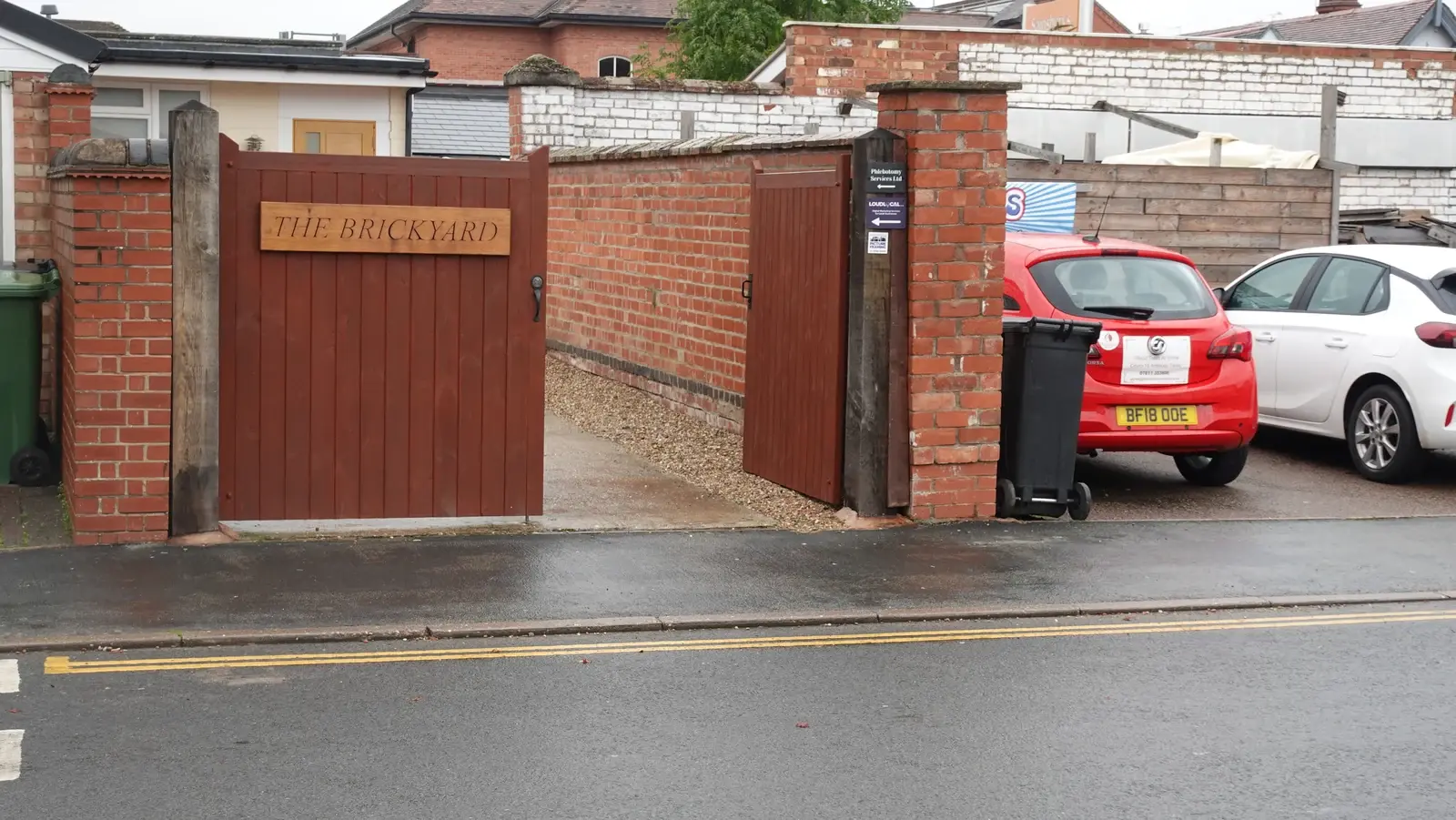 The Brickyard entrance with wooden gates, brick walls and a LoudLocal sign.