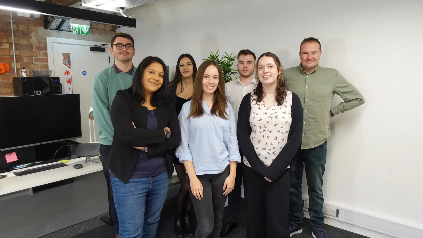 Seven LoudLocal team members standing together in the office.