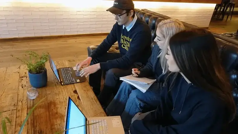Three LoudLocal colleagues with laptops and a notebook during a team photoshoot at the Almanac in Kenilworth.