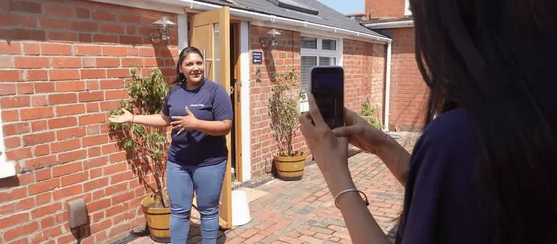 Priya being filmed on a phone outside the brick-built entrance to the Brickyard, LoudLocal’s first office.