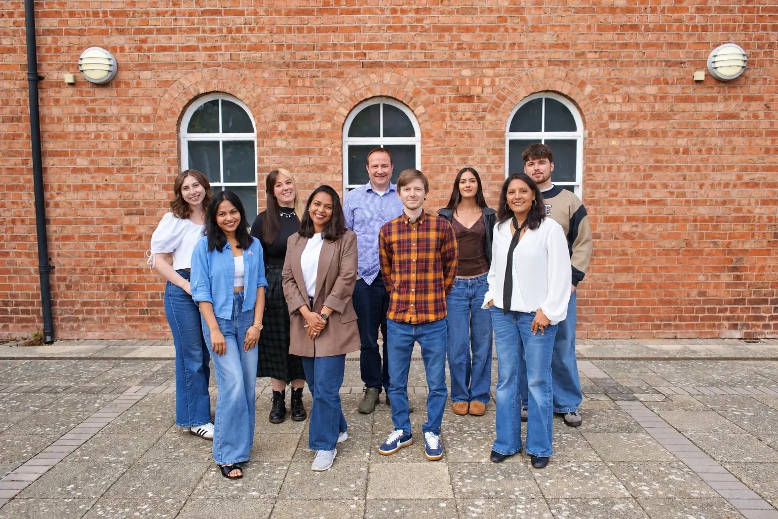 The LoudLocal team standing outside a brick building.