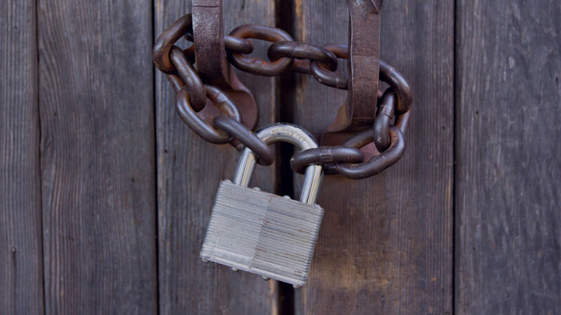 Image of a padlock and chain on a wooden door, indicating when someone gets locked out of their own business advertising accounts
