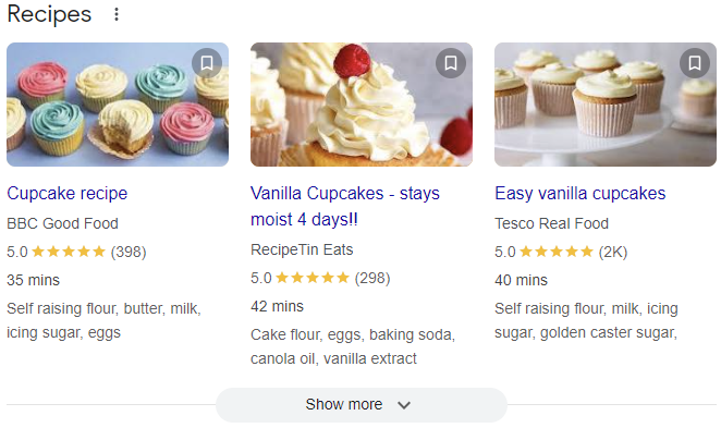 A carousel of recipes displayed in a row with an arrow option to scroll and view more options. These recipes include a small photo of the food, the title of the recipe, reviews, small description, the website, and the cooking duration. 