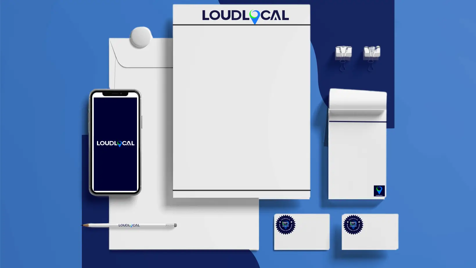 An image with different items that would be used in marketing such as headed paper, business cards, phone, branded pencil and envelopes all with the LoudLocal logo on on a blue background