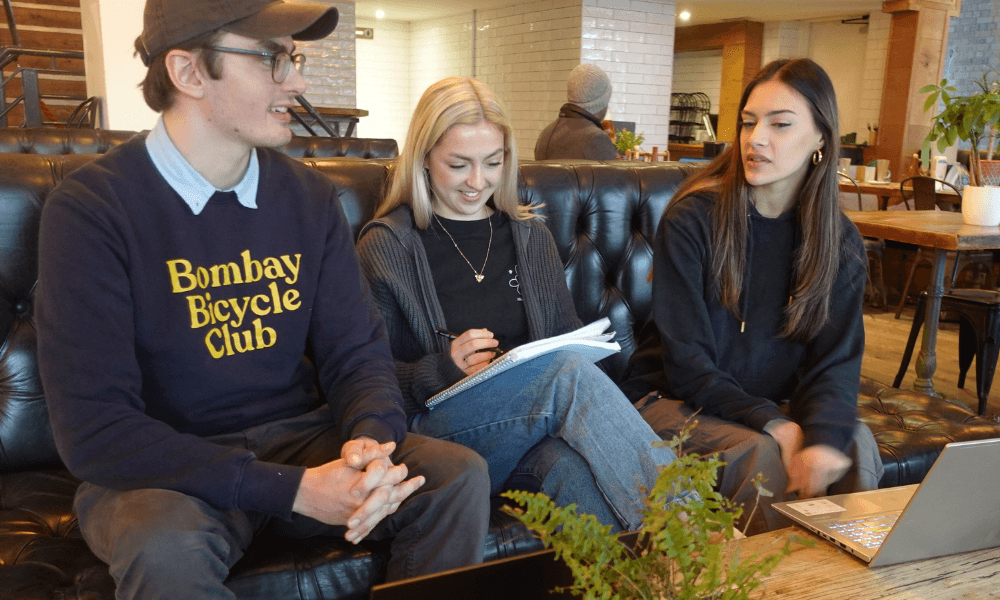 An image showing Toby, Tanya and Taya from the LoudLocal team sat in an office discussing a project 